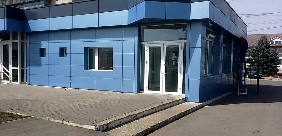 Clădire parter placată cu bond albastru în două nuanțe, cu uși și ferestre albe