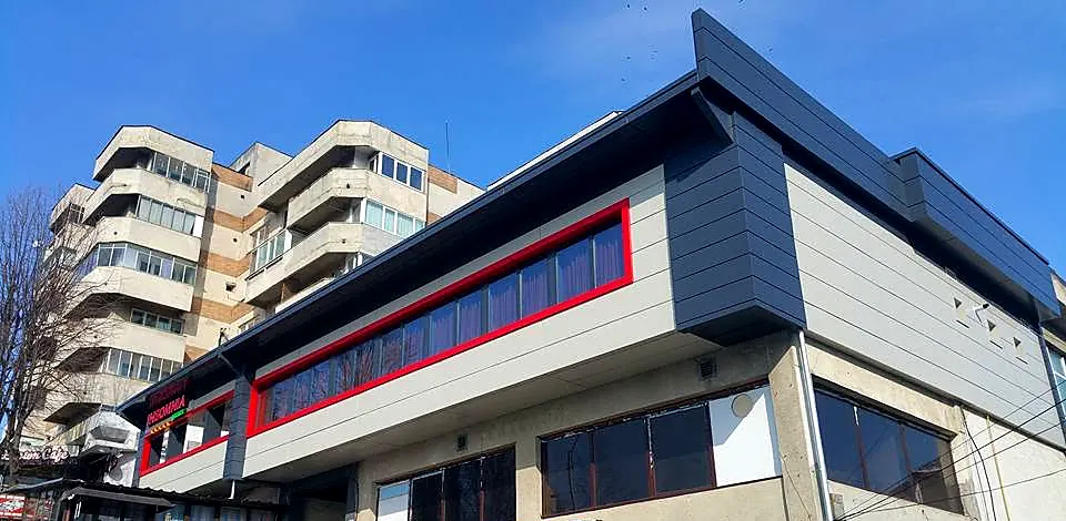 Clădire comercială cu restaurant la etaj, placată cu bond gri antracit și ancadramente din bond roșu