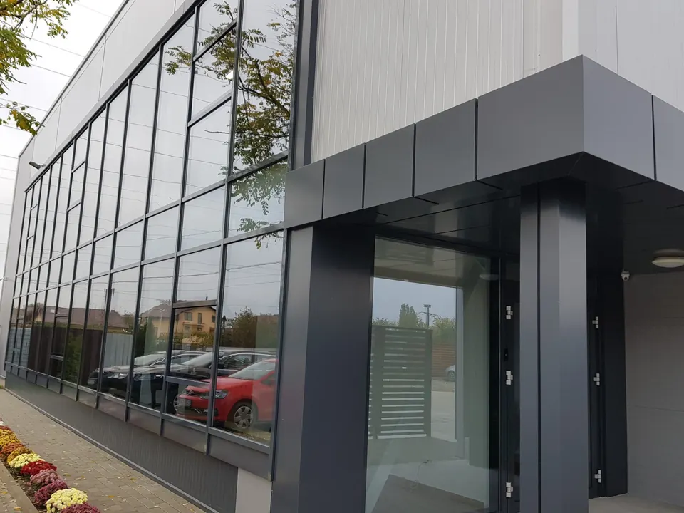 Clădire comercială cu perete cortină din sticlă și portal placat cu bond antracit