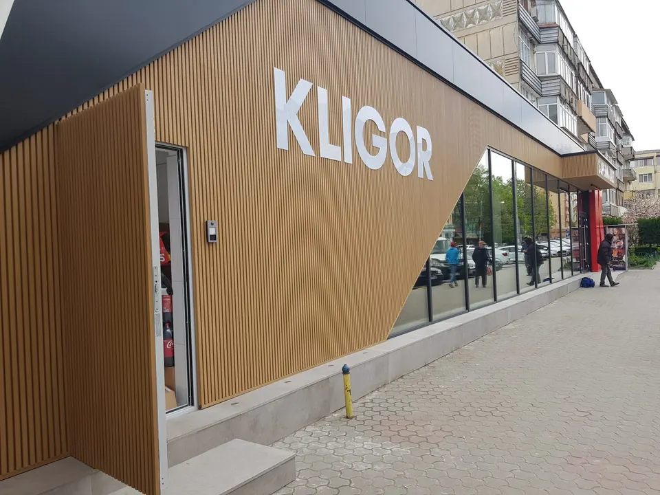 Fațadă de magazin placată cu riflaje din aluminiu cu efect de lemn și vitrine din sticlă