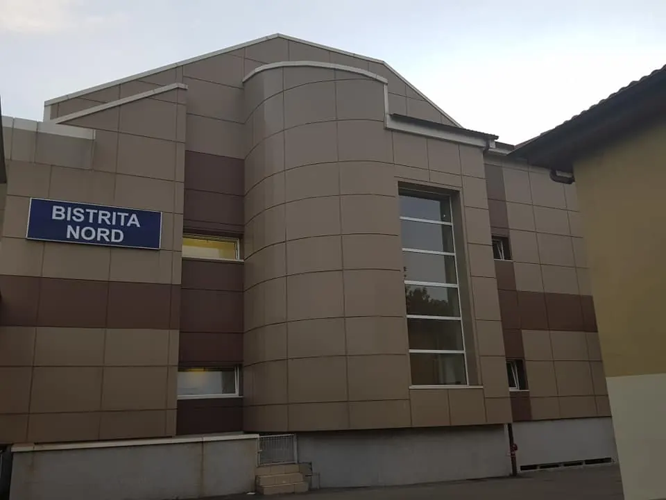 Clădirea gării Bistrița Nord cu fațadă placată cu bond maro, inclusiv pe suprafețe curbe