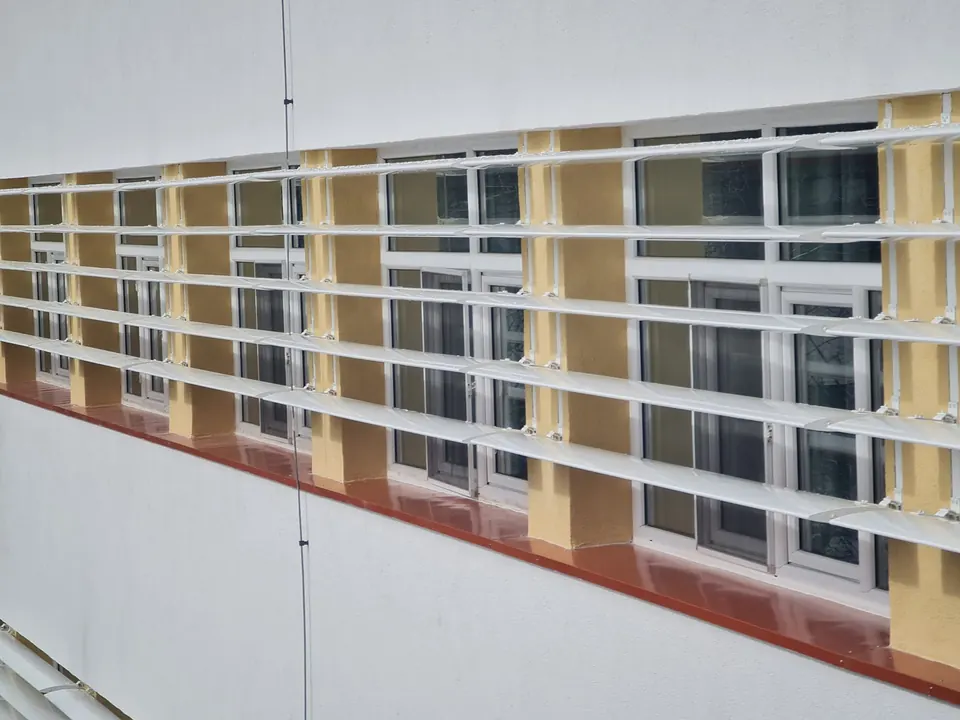 Parasolare din aluminiu cu lamele orizontale montate peste ferestrele unei clădiri