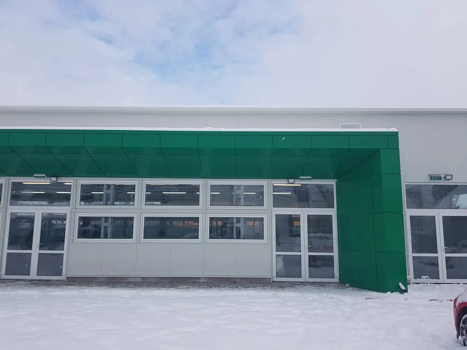 Hală cu copertină placată cu bond verde, uși și ferestre din aluminiu