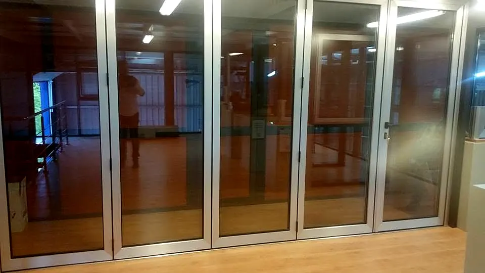Perete din uși pliante din sticlă și aluminiu, închis, într-un spațiu interior